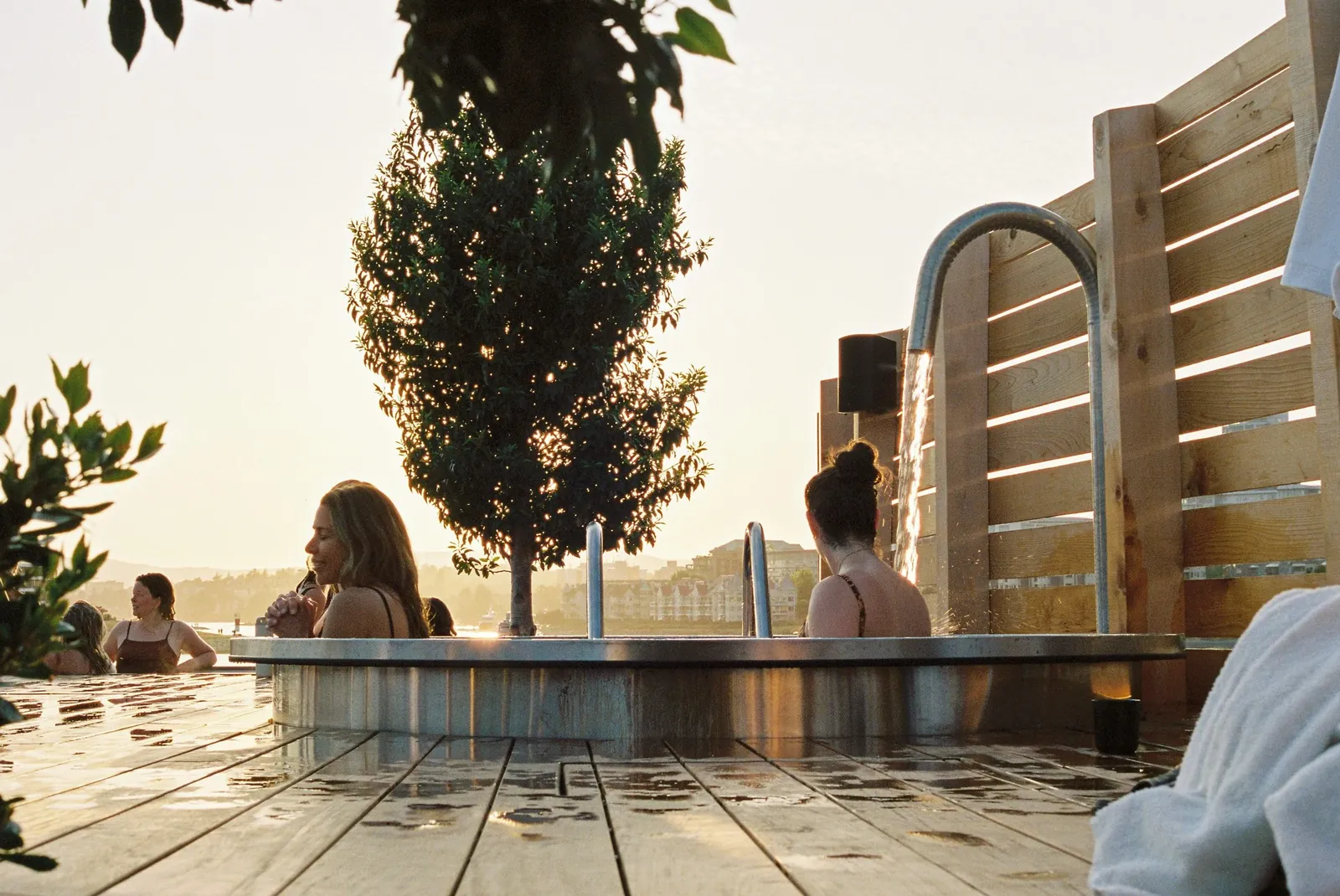 Outdoor soaking pools at Havn at golden hour, with the water beyond