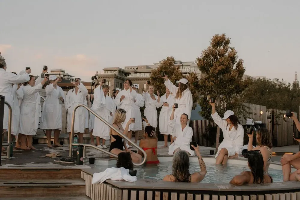 Women in white robes gathered around outdoor pools